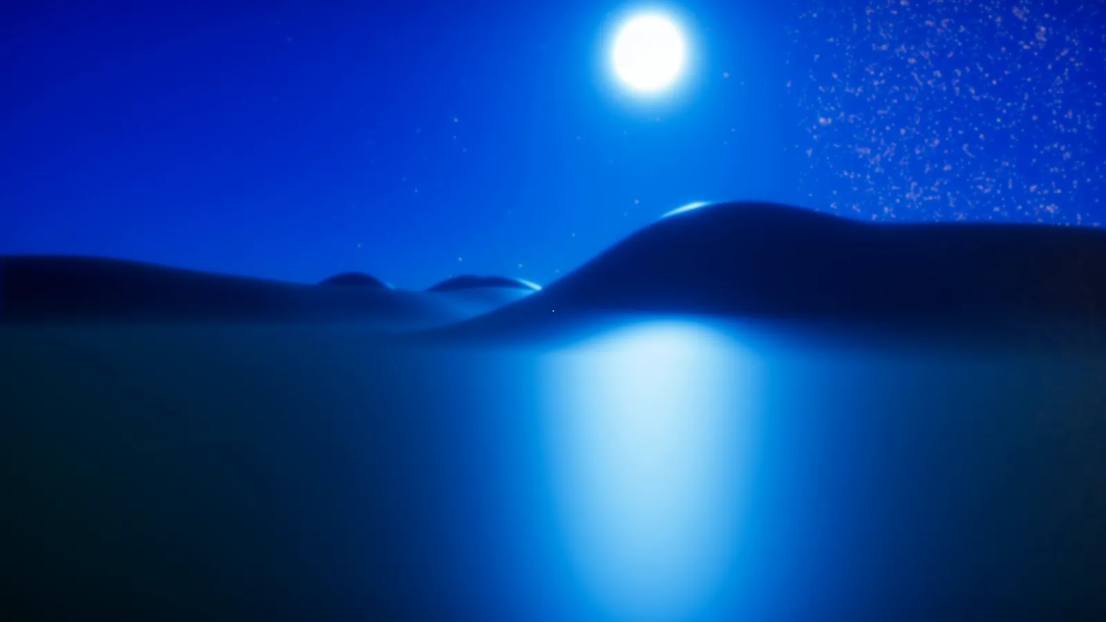 A full moon reflected on blue desert sand